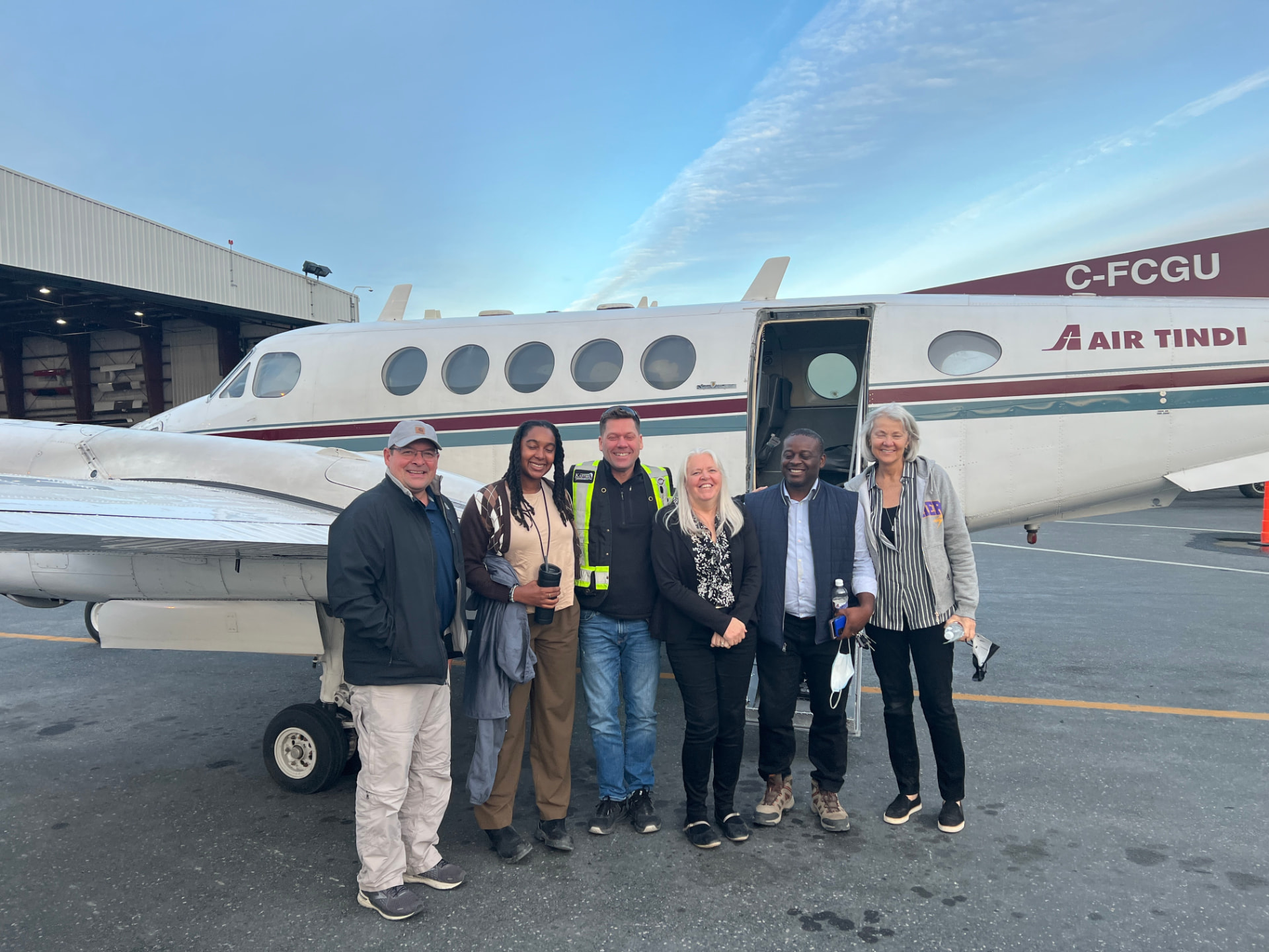 The Kuponya team and community partners boarding a flight to a northern community