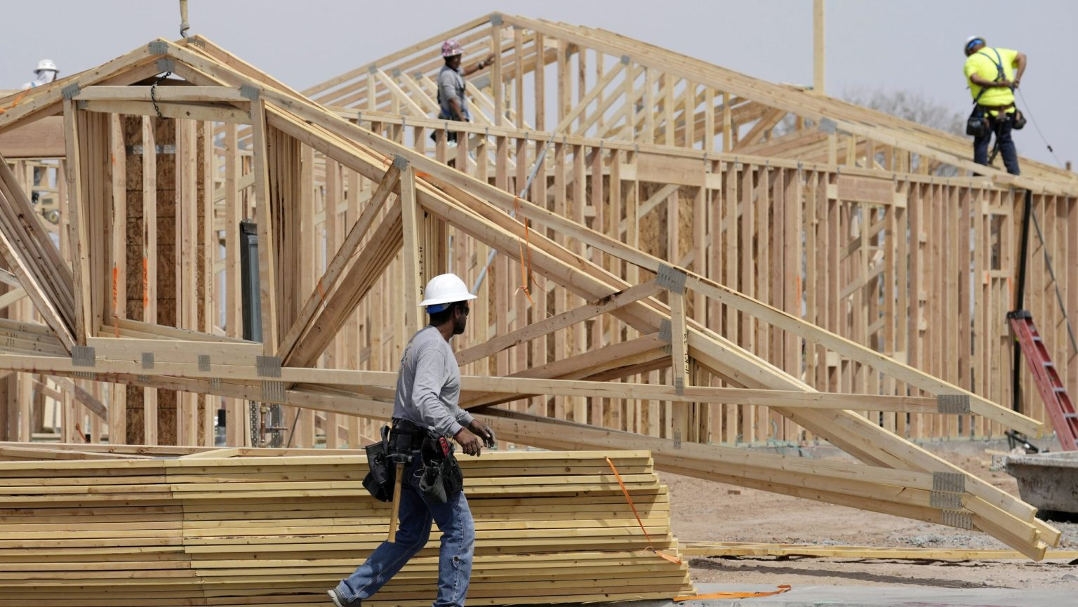 Framing crew building wood-frame houses on a subdivision site